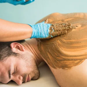 handsome-latin-young-man-getting-massage-mud-bath-his-visit-spa